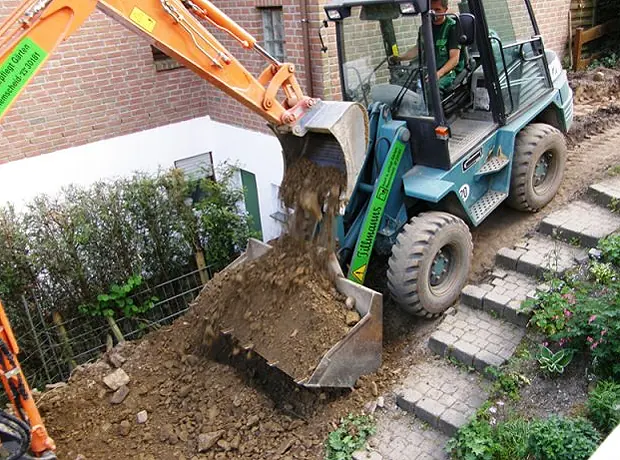 Radlader transportiert Aushub entlang der neuen Treppenanlage