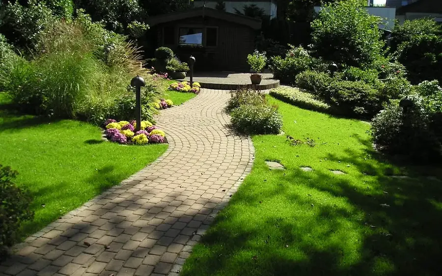 Gartenweg aus Pflaster im Bogenverband mit Wegeleuchten