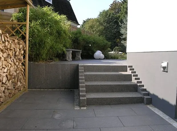 Feuerholzlager unter einem Holzunterstand neben der Treppenanlage